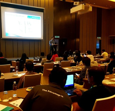 Ka Hoe presenting to an audience seated at tables