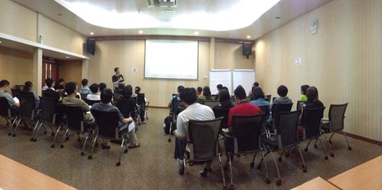 Ka Hoe speaking to a seated audience in a classroom